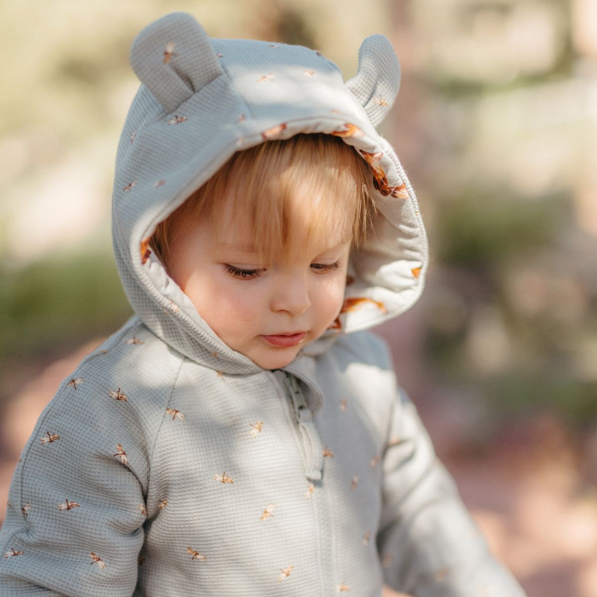 Close up of a toddler or baby wearing the Fox and Dragonfly Reversible Waffle Knit Quilted Hooded Jumpsuit with a focus on the animal ears