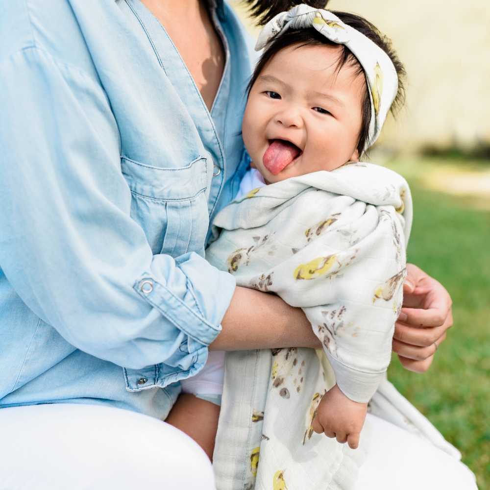Mom and Daughter wrapped in Milkbarn's Big Lovey Muslin Blanket in the Blue Birds print
