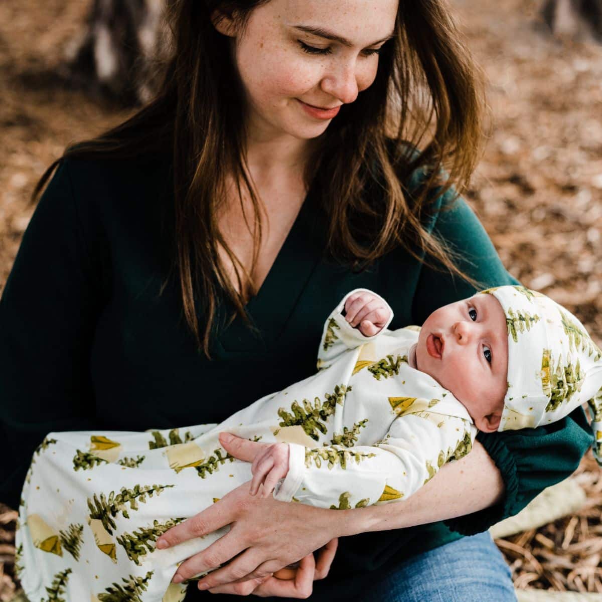 Mom and newborn babt outside wearing the bamboo Camping Gown and Hat set by Milkbarn Kids.