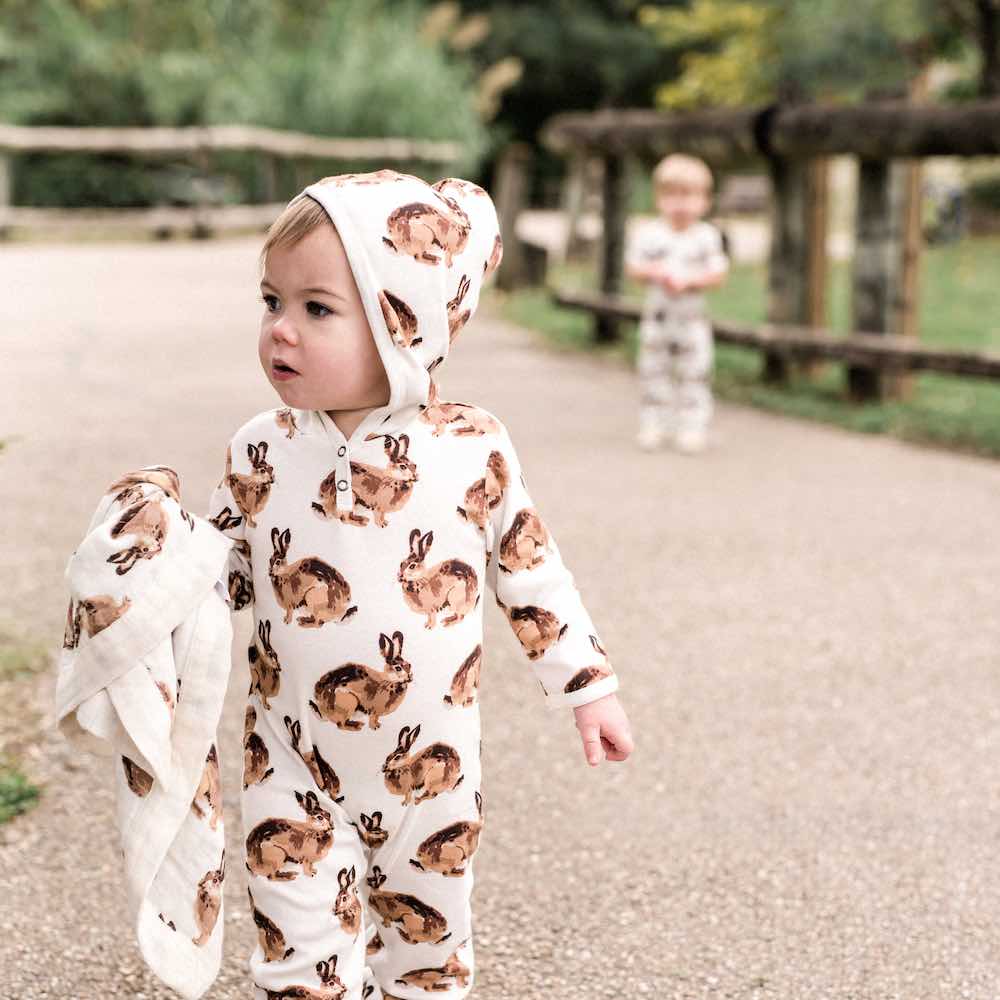 Littel Boy and Friend at the Park Wearing a Organic Cotton Hooded Romper in the Bunny or Rabbit Print by Milkbarn Kids