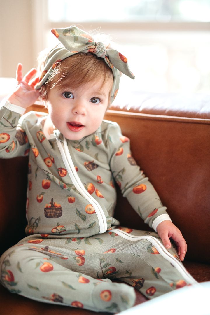 1 to 2 year old baby sitting wearing Milkbarn Organic Cotton zipper footed romper and knotted headband in Apple Orchard print, cozy toddler outfit for fall