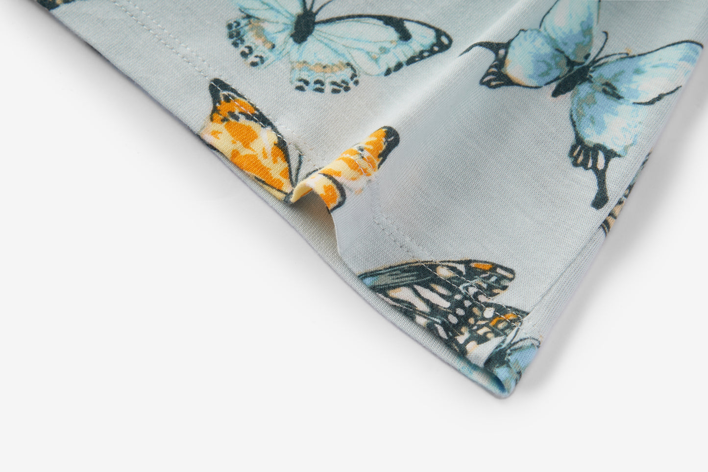 Closeup detail of garment edge and butterfly print on Milkbarn Bamboo Dress and Bloomer Set, soft 100% rayon from bamboo fabric