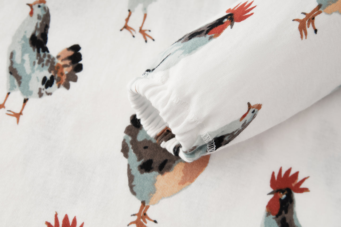Closeup of sleeve and chicken print on Milkbarn Organic Cotton Dress and Legging Set, eco-friendly white cotton fabric with playful rooster and chicken design for girls