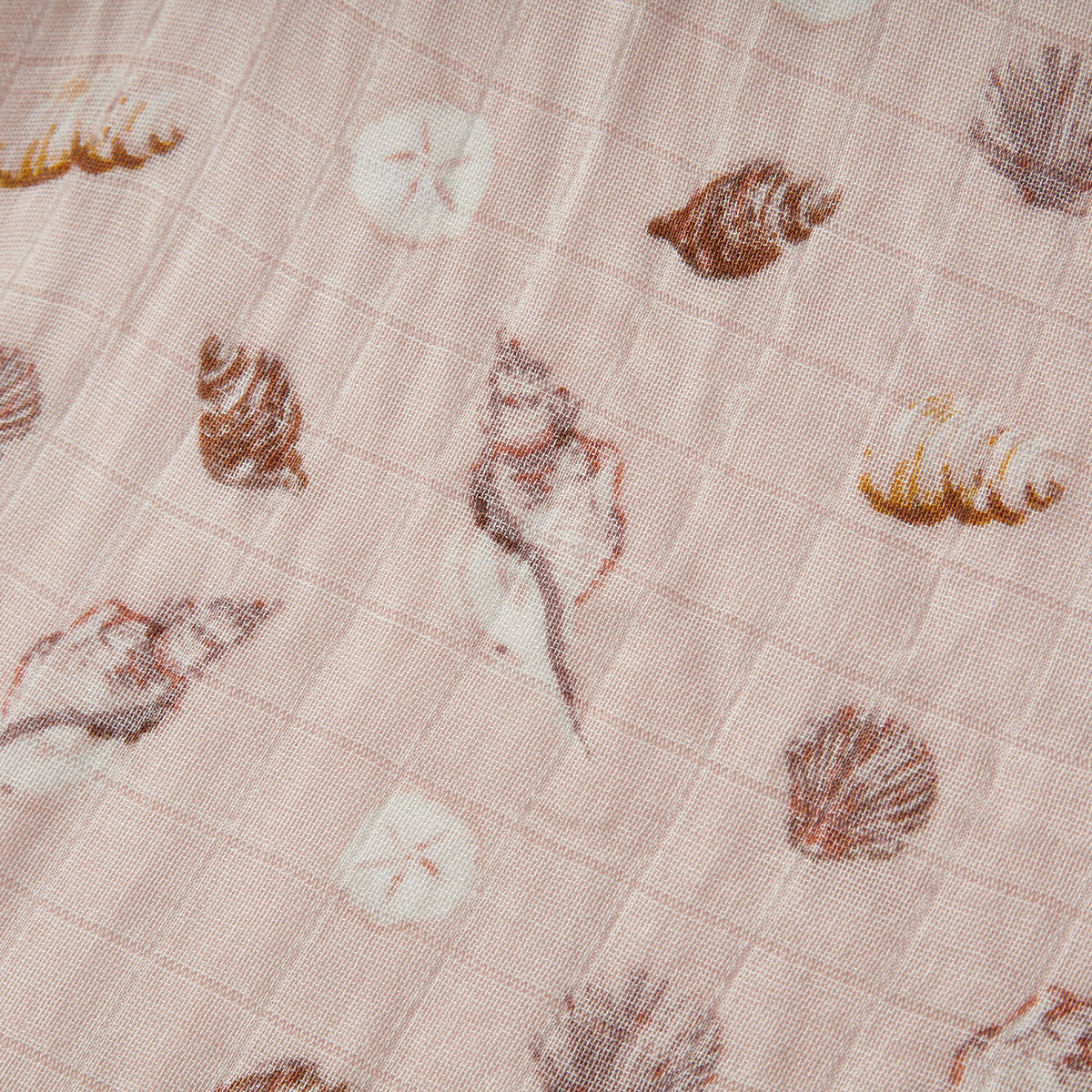 Closeup of Milkbarn Seashells Bamboo Muslin Swaddle Blanket, showing soft breathable 70% rayon bamboo and 30% cotton fabric with playful seashell and sand dollar print for newborns