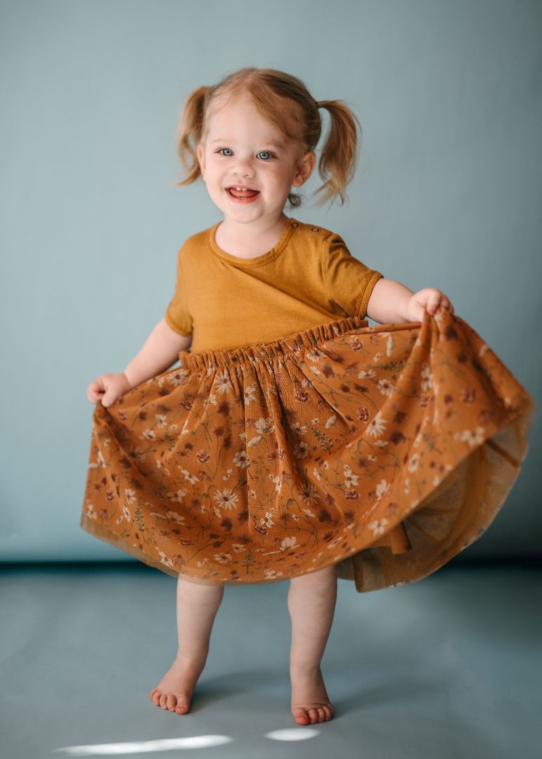 Toddler girl in Wildflower ballet dress pulls tulle skirt out on both sides showing bamboo top