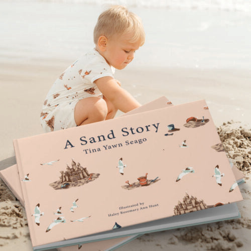 A Sand Story by Tina Yawn Seago, a children’s book for ages 3–6 about resilience and hope, featuring a small grain of sand traveling through the ocean with pink cover, white seagulls, and brown sandcastles, perfect for reading with matching Milkbarn pajamas