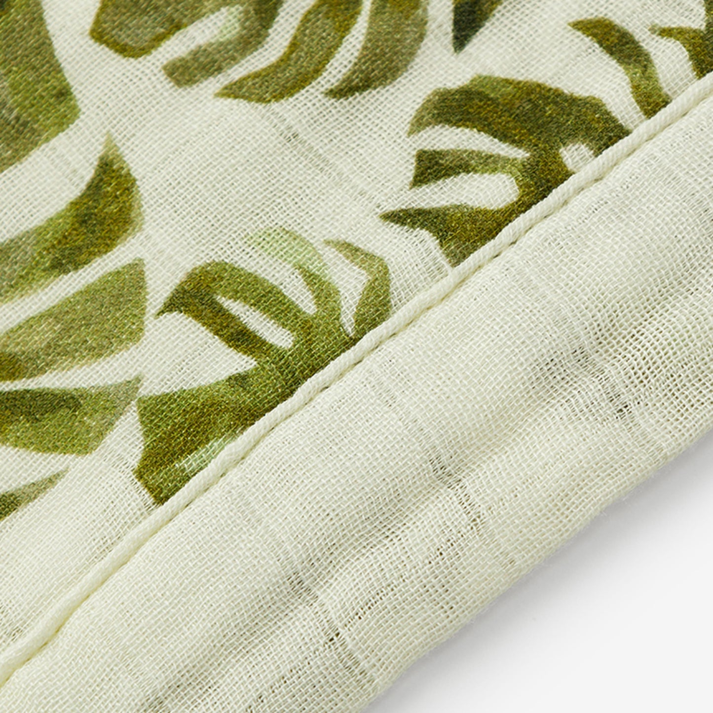 Closeup of Island Leaf Bamboo Mini Lovey muslin leaf print fabric and trim