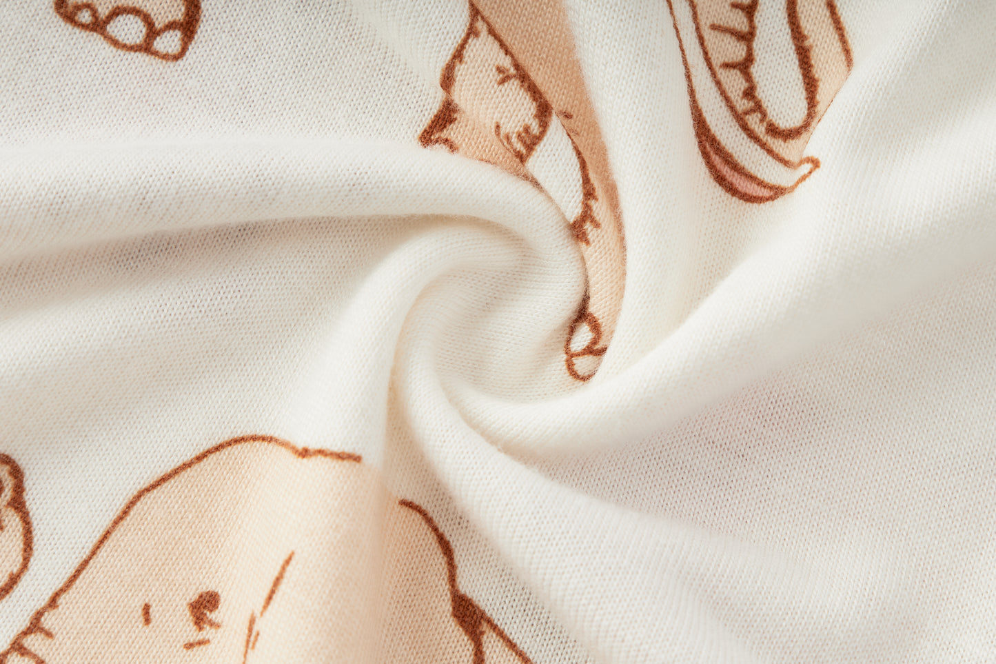Close-up detail of Milkbarn organic baby girl bamboo dress and bloomer set in Tutu Elephant print, showing white fabric with pink elephants wearing tutus