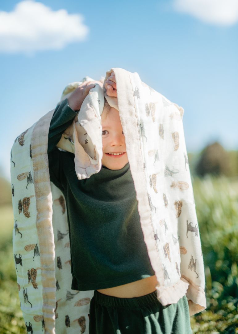 Little boy standing in a grassy field holdingLittle boy standing in a grassy field holding Milkbarn’s soft and breathable bamboo-cotton Big Lovey blanket in Cat print above his head.

Little boy standing in a grassy field holding Milkbarn’s soft and breathable bamboo-cotton Big Lovey blanket in Cat print above his head.