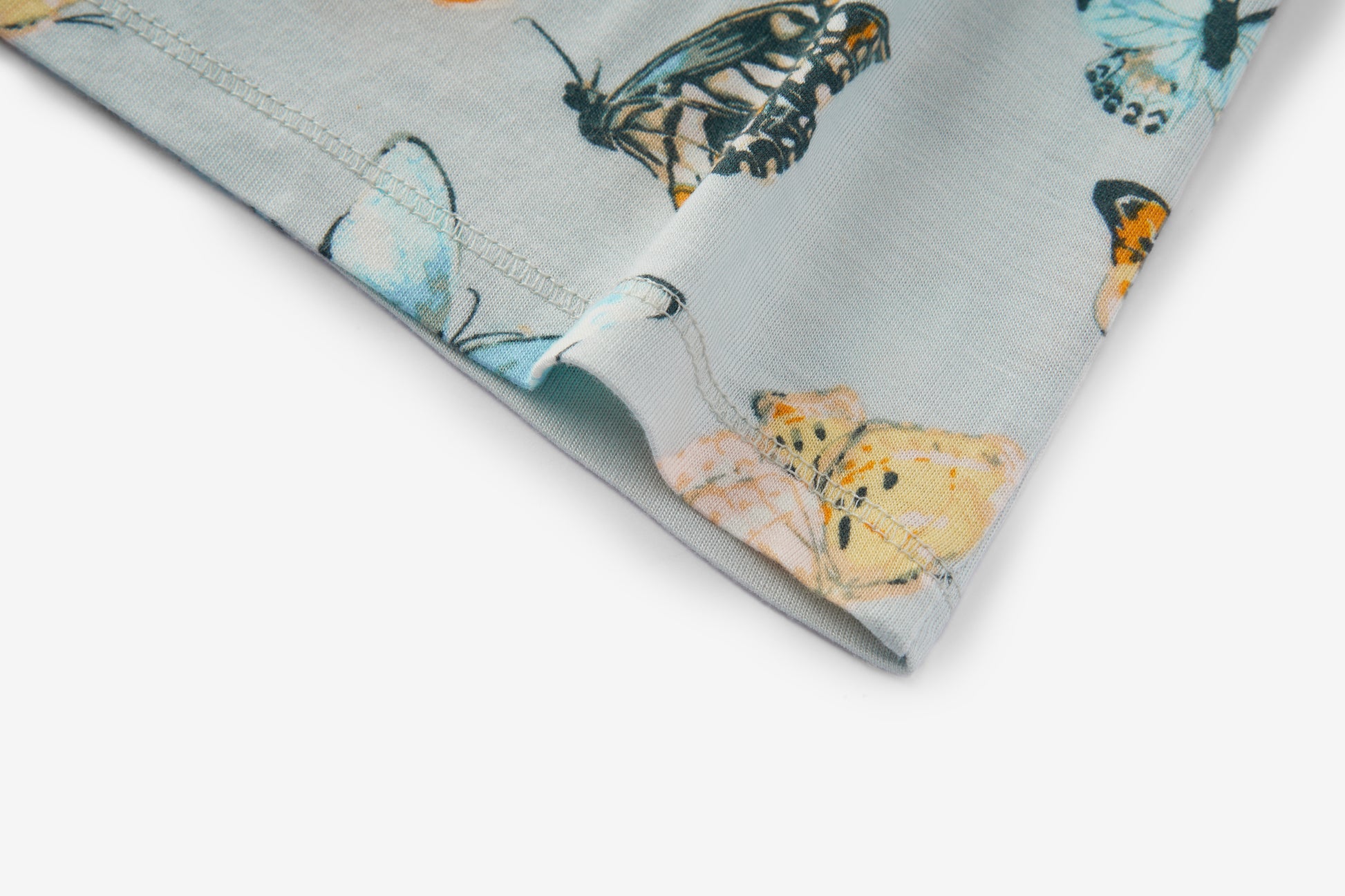 Closeup of edge and seam on Milkbarn Butterfly Bamboo Dress and Legging Set, showing durable stitching and soft eco-friendly blue bamboo fabric with butterfly pattern
