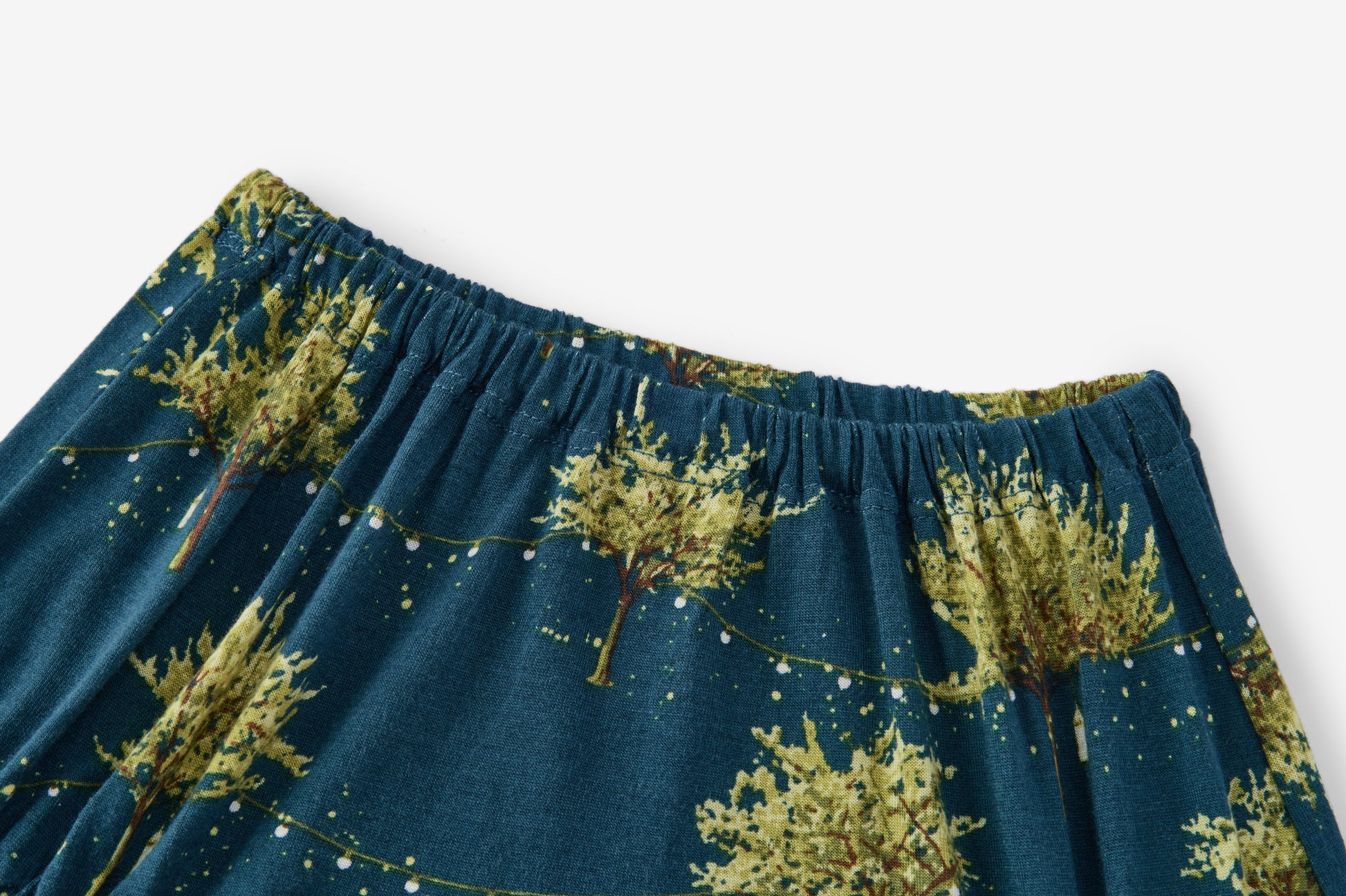 Closeup detail of Milkbarn Firefly Bamboo Dress and Bloomer Set elastic waistband showing dark blue rayon from bamboo fabric with glowing fireflies, lanterns, and trees print