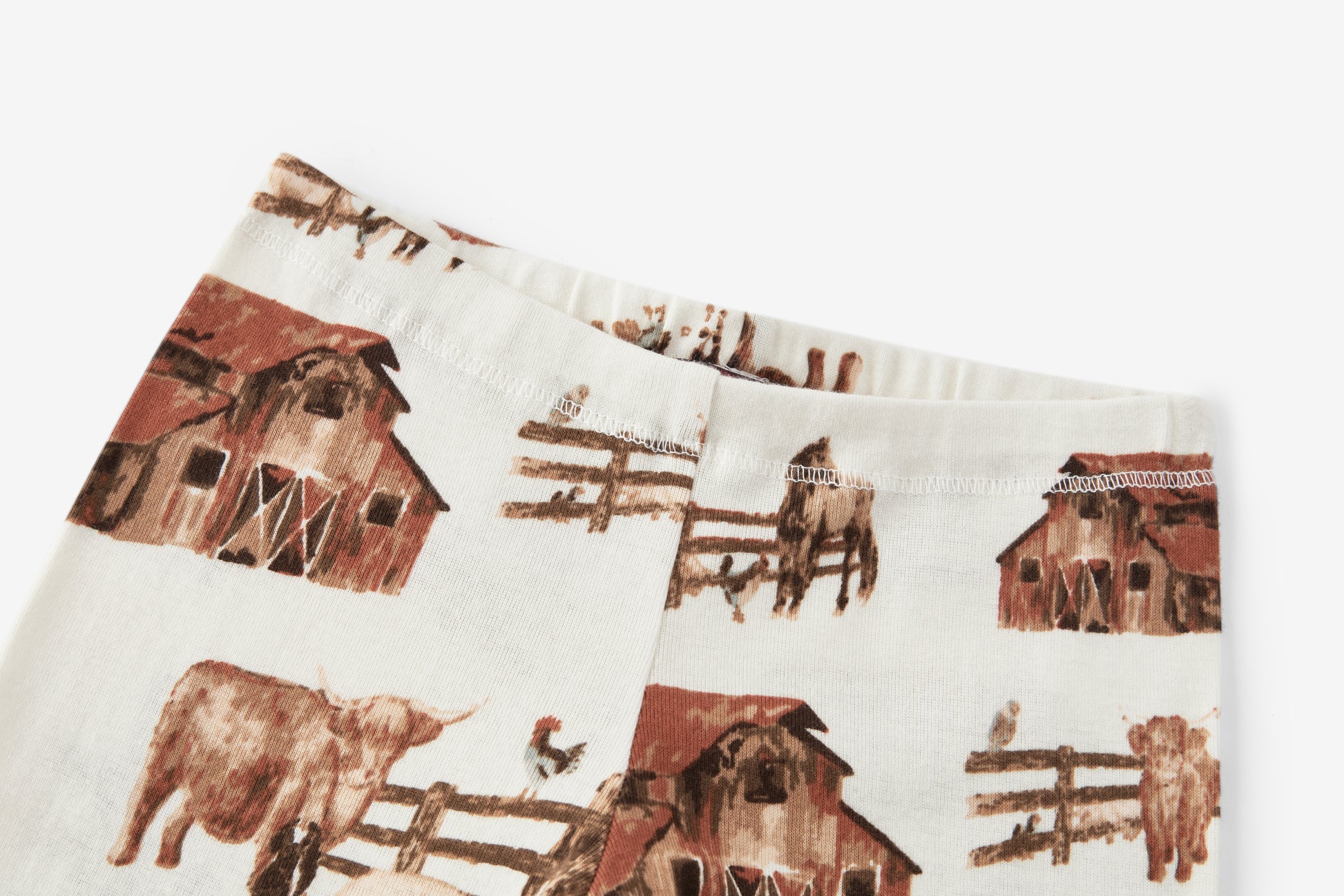 Closeup of bloomers on Milkbarn Homestead Organic Cotton Dress and Legging Set, showing elastic waistband and detailed farm animal print with barn, horse, cow, chicken, and pigs