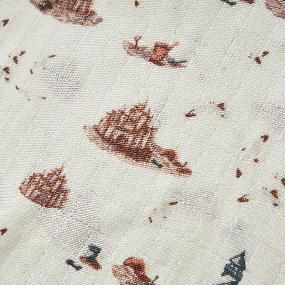 Closeup of Milkbarn Sandcastle Mini Lovey Two-Layer Muslin Security Blanket fabric, double-layer bamboo and cotton muslin with playful sandcastle, lighthouse, and seagull print