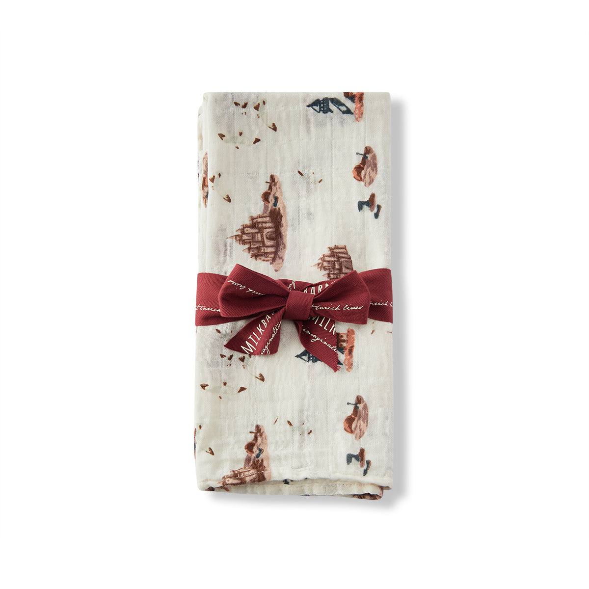 Milkbarn Sandcastle Organic Cotton Muslin Two-Piece Burp Cloth Set wrapped with ribbon, white eco-friendly fabric with beach-themed sandcastle, lighthouse, and seagull design