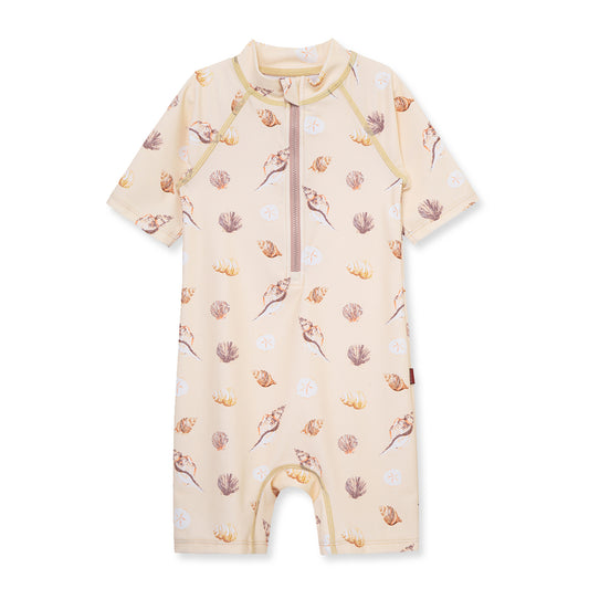 Milkbarn Seashells zipper shortall swimsuit in soft pink, adorned with delicate seashells and offering UPF 50+ sun protection for little beachgoers.