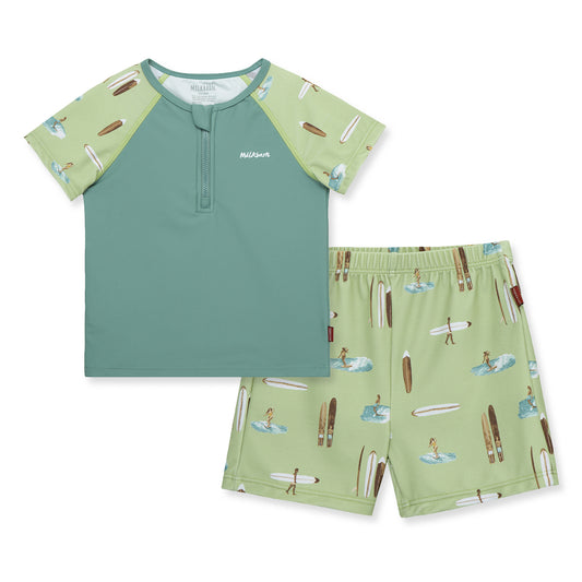 Front view of Milkbarn Summer Surf zipper swim top and trunks set for babies and toddlers, blue body with surfer print sleeves, UPF 50+ rash guard and trunks.
