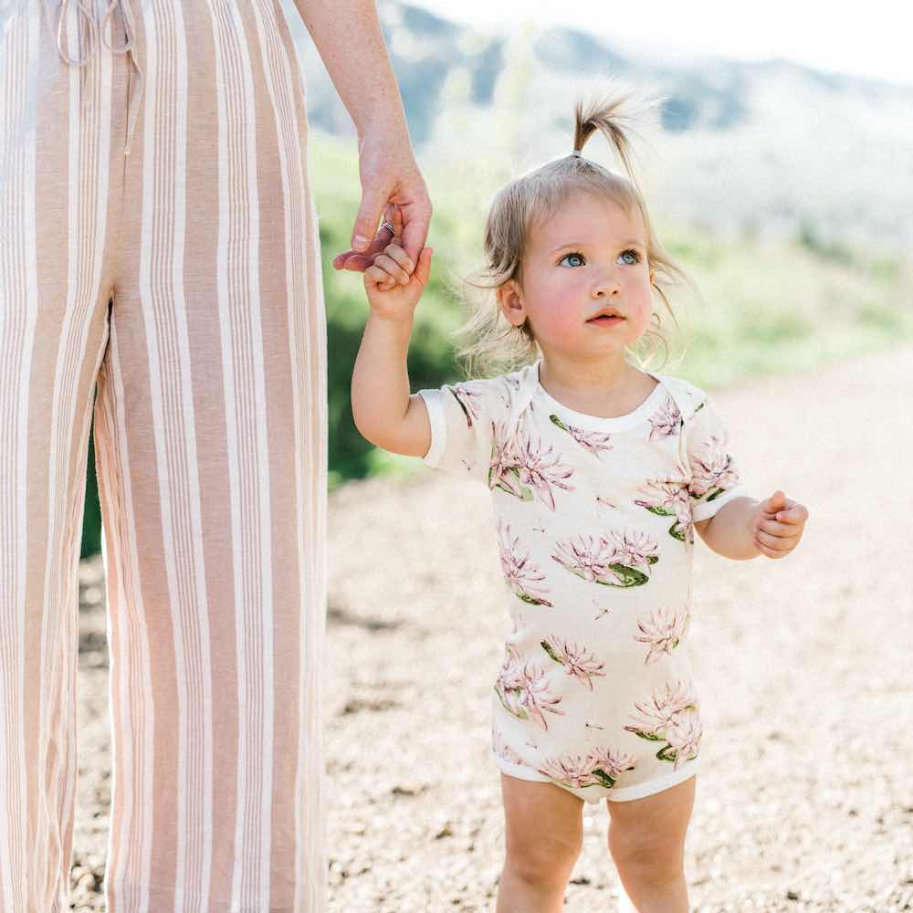 Mom Holding the Babies Hand Wearing Bamboo One Piece or Onesie in the Water Lily Print by Milkbarn Kids