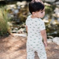 Baby Boy by a Pond Wearing the Grasshopper Organic Cotton Romper by Milkbarn Kids