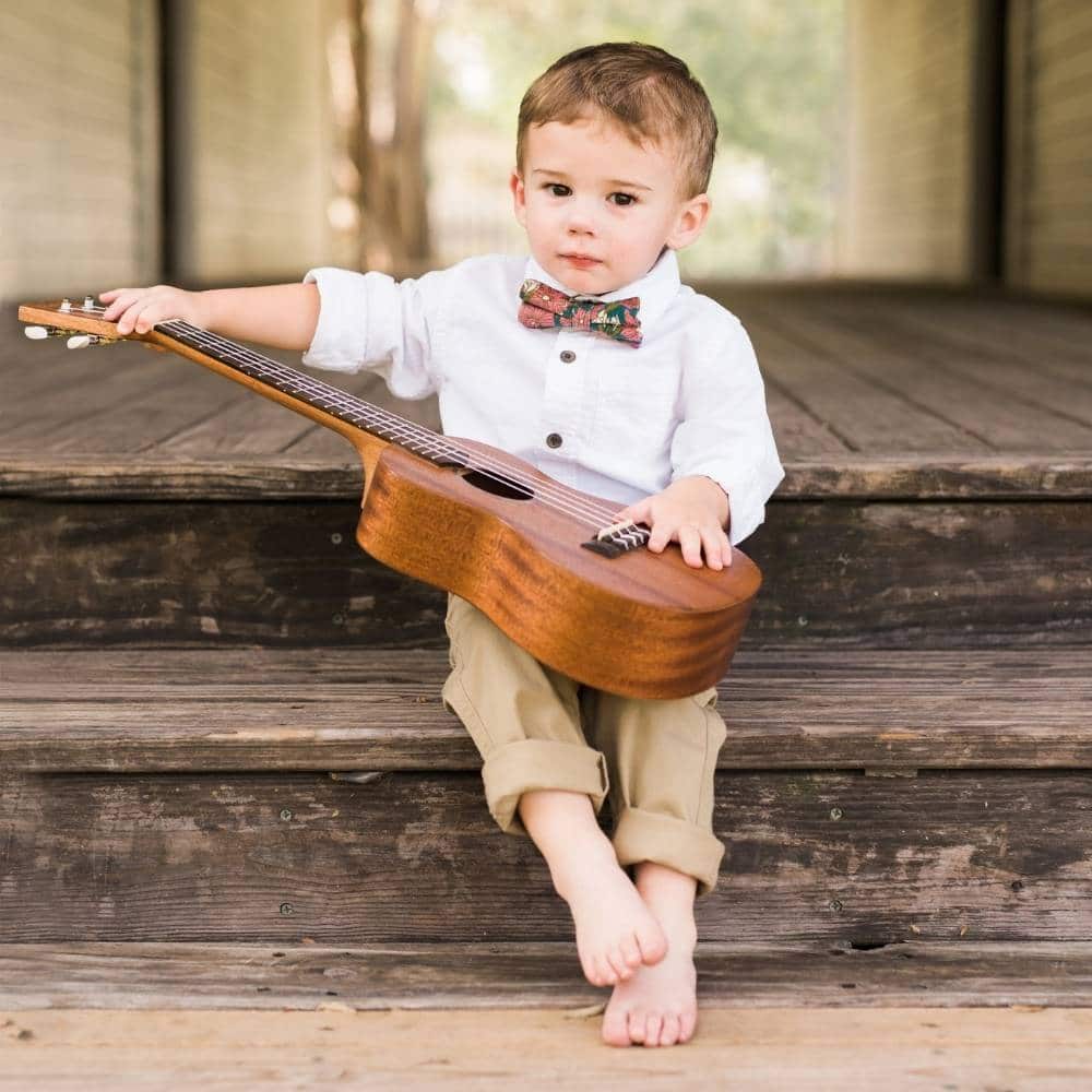 Boy on Steps Playing the Guitar Wearing Teal Floral Bow Tie by Milkbarn Kids