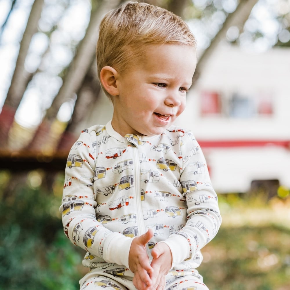 Baby Boy Sitting Wearing the Organic Cotton Vintage Trailers Zipper Pajamas by Milkbarn Kids