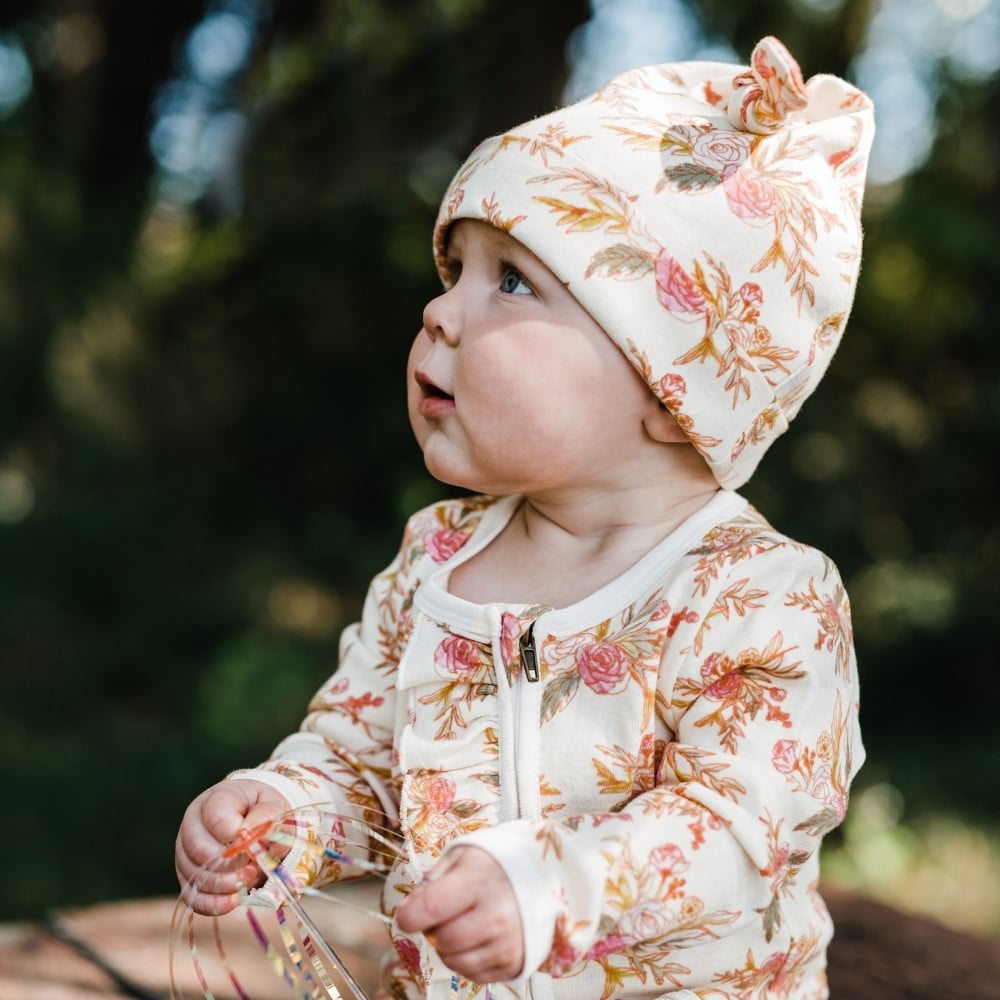 Baby Girl Looking Up wearing the Vintage Floral Organic Knotted Beanie Hat by Milkbarn Kids
