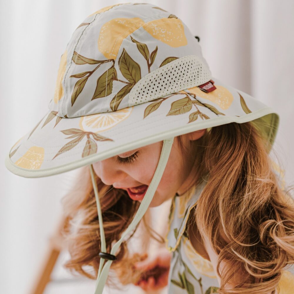 Toddler girl wearing the Lemon Sun Safety Adjustable Hat