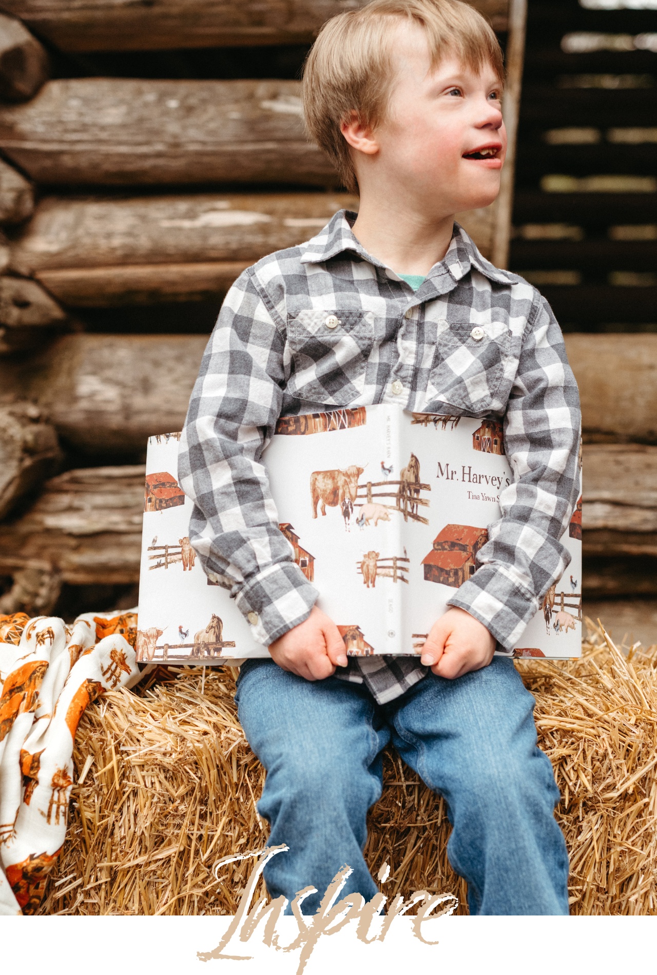 A boy sits on a bale of hay on a far holding the children's book, Mr. Harvey's Barn by Tina Yawn Seago with Illustrations by Haley Hunt for Milkbarn Kids